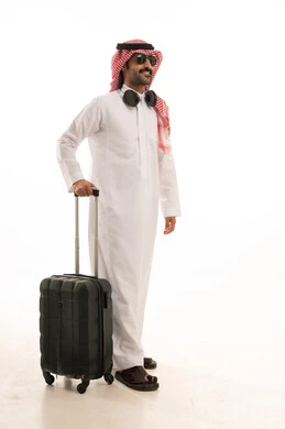 الاستعداد لقضاء رحلة صيفية ممتعة، مفهوم السياحة في إجازة الصيف، القيام بالجولات الترفيهية، بورتريه لرجل عربي خليجي سعودي يرتدي الزي التقليدي والشماغ يحمل شنطة سفر بتعابير السرور، خلفية بيضاء