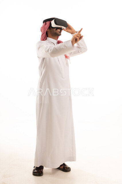 Integrating modern technologies into daily life, expressions of integration and simulation of the imaginary world, an attempt to interact with things, a portrait of an Arab Saudi Gulf man wearing a white thobe and a ghutrah, wearing 3D glasses, with a white background.