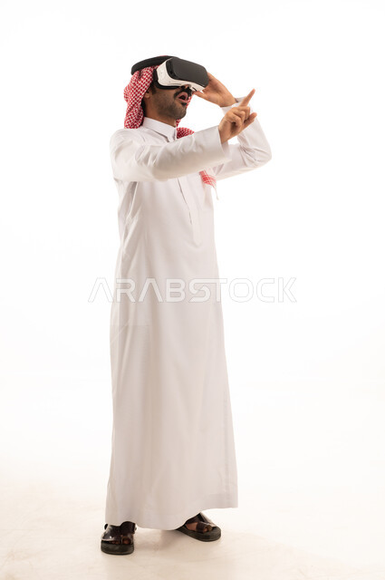 دمج التقنيات الحديثة فى الحياة اليومية، تعابير الاندماج ومحاكاة العالم الخيالي، محاولة التفاعل مع الاشياء , بورتريه لرجل عربي سعودي خليجي يرتدي الزي الثوب الابيض والشماغ يضع نظارة ثلاثية الأبعاد, خلفية بيضاء