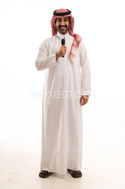 إيماءات الإندماج والتفاعل مع الغناء، تسجيل مقطع صوتي غنائي،  بورتريه لرجل عربي خليجي سعودي يرتدي الثوب التقليدي والشماغ ويمسك المايكروفون ويغني بحماس، تقديم العروض الفنية المسرحية والفقرات الترفيهية، خلفية بيضاء.