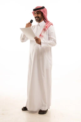 تقديم الفقرات باستخدام الميكروفون، اعداد التقارير الخاصة بالعمل، متابعة ومراجعة الخطط والمشاريع المكتبية، بورتريه لرجل عربي خليجي سعودي يرتدي الثوب التقليدي والشماغ ينظر الى الاوراق البيضاء يمسك بيده المايك، الجسم بالطول الكامل، خلفية بيضاء