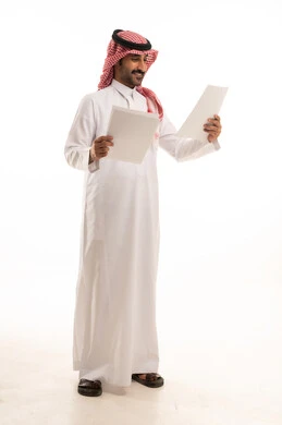 التدقيق في قراءة الملاحظات، بورتريه لسكرتير عربي خليجي سعودي يرتدي الثوب التقليدي والشماغ ويحمل بيده مجموعه من الاوراق البيضاء، اعداد التقارير الخاصة بالعمل، مراجعة ومتابعة الخطط والمشاريع المكتبية، خلفية بيضاء