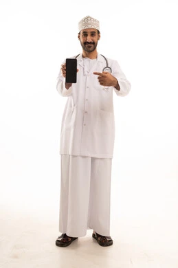 The integration of technology and technology in medicine and healthcare, working in the medical sector in the Sultanate of Oman, a portrait of an Arab Gulf Omani doctor wearing a dishdasha and kumma and the professional attire, wearing a stethoscope, using a mobile phone with expressions of joy, full-body, white background.
