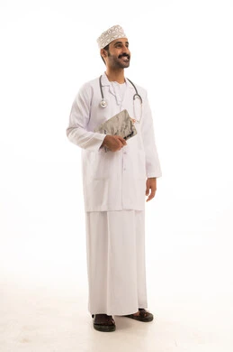 Working in the health sector, a portrait of an Arab Gulf Omani doctor wearing a dishdasha, turban, medical coat, and mask, holding a stethoscope and medical reports in hand, full-body shot, white background.