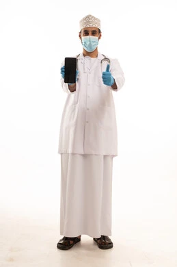 تعابير الموافقة والرضي، دمج التقنية والتكنولوجيا في الطب والرعاية الصحية، العمل في القطاع الطبي في سلطنة عمان، بورتريه لطبيب عربي خليجي عماني يرتدي الدشداشة والكمة والزي الخاص بالمهنة يضع السماعة الطبية يستخدم  الهاتف المحمول ، الجسم بالطول الكامل، خلفية بيضاء