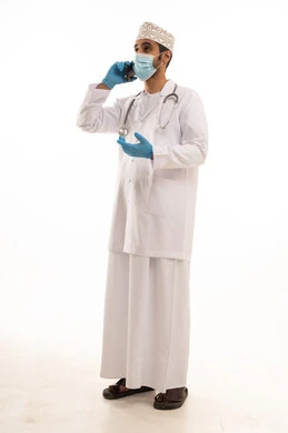 اتباع اجراءات السلامة للوقاية من فايروس كورونا، دمج التقنية والتكنولوجيا في الطب والرعاية الصحية، العمل في القطاع الطبي في سلطنة عمان، بورتريه لطبيب عربي خليجي عماني يرتدي الدشداشة والكمة والزي الخاص بالمهنة يضع السماعة الطبية يستخدم الهاتف المحمول بتعابير السرور، الجسم بالطول الكامل، خلفية بيضاء اتباع اجراءات السلامة للوقاية من فايروس كورونا، دمج التقنية والتكنولوجيا في الطب والرعاية الصحية، العمل في القطاع الطبي في سلطنة عمان، بورتريه لطبيب عربي خليجي عماني يرتدي الدشداشة والكمة والزي الخاص بالمهنة يضع السماعة الطبية يستخدم الهاتف المحمول بتعابير السرور، الجسم بالطول الكامل، خلفية بيضاء