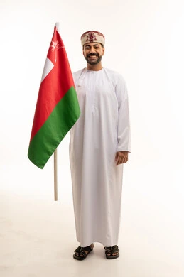 رجل عماني يحمل علم عمان على خلفية بيضاء
