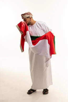 Omani Man Kissing National Flag in Traditional Dress