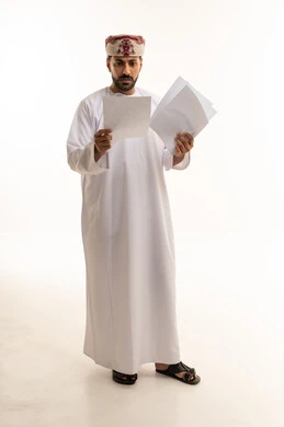 Omani Man in Traditional Dress Reviewing Documents