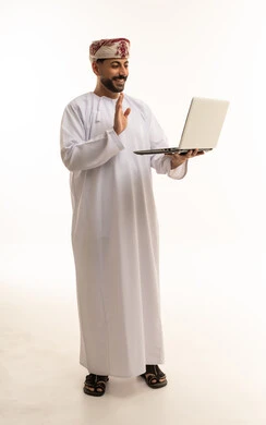 رجل عماني يحمل كمبيوتر محمول يلوح بيده خلفية بيضاء