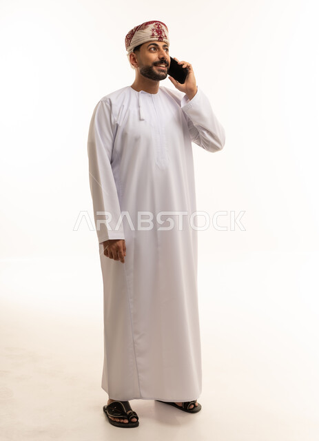 Omani Man in Traditional Dishdasha Using Smartphone