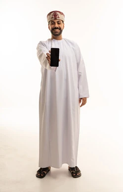 رجل عماني يعرض شاشة هاتف ذكي بخلفية بيضاء