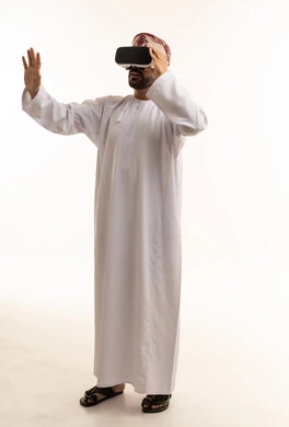 رجل عماني يرتدي سماعة واقع افتراضي بالزي التقليدي