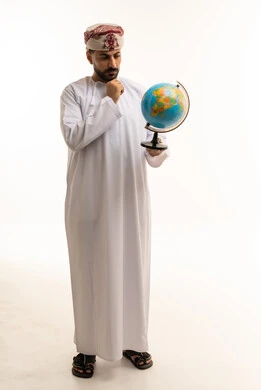 رجل عماني بوضعية تفكير يحمل مجسم الكرة الأرضية