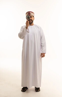 Omani Man in Traditional Dress Using Magnifying Glass