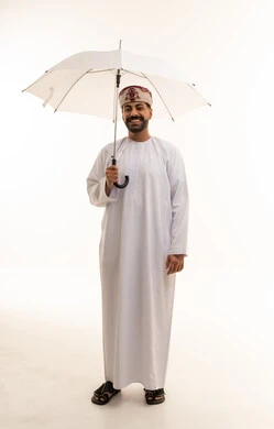 Omani Man in Traditional Dress Holding Umbrella