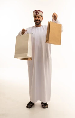رجل عُماني يحمل حقائب تسوق على خلفية بيضاء