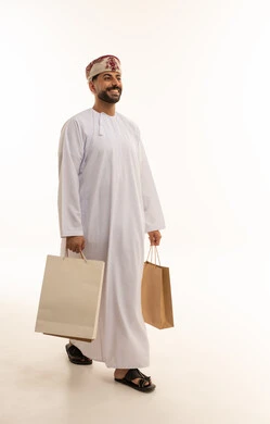 Omani Man Walking with Shopping Bags on White Background