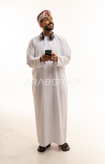 Omani Man in Traditional Dress Using Smartphone