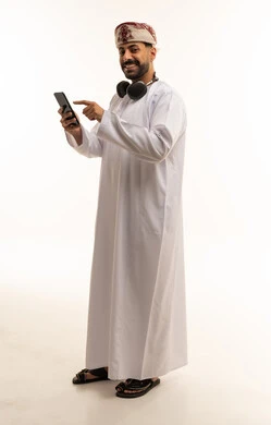 رجل عماني يشير إلى هاتف ذكي في الاستوديو