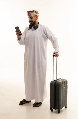 رجل عُماني مسافر مع حقيبة وهاتف ذكي