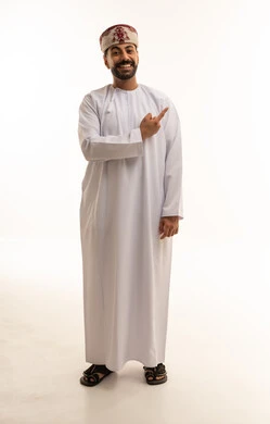 رجل عُماني بالزي التقليدي يشير بيده في استوديو