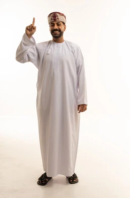 رجل عُماني بالزي التقليدي يشير بإصبعه للأعلى