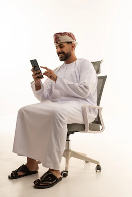 Omani Man in Traditional Dress Using Smartphone