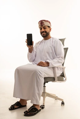 رجل عماني بالزي التقليدي يحمل هاتف ذكي