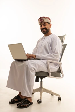 Omani Man Using Laptop in Traditional Dishdasha