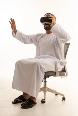 Omani Man Using Virtual Reality Headset in Traditional Dress