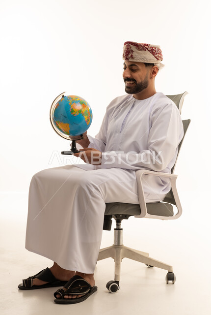 Omani Man in Traditional Dress Holding a Globe