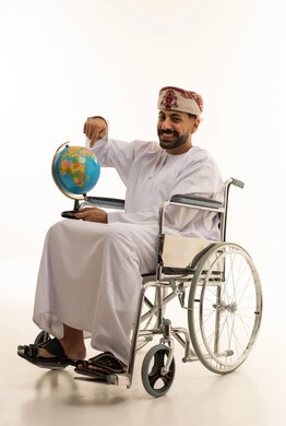 رجل عُماني على كرسي متحرك يحمل الكرة الأرضية