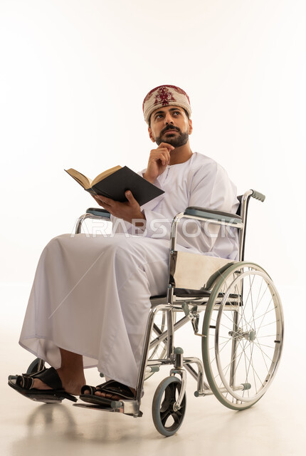 رجل عماني على كرسي متحرك يقرأ كتاباً