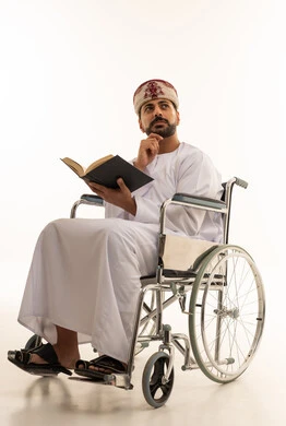Omani Man in Wheelchair Reading Book on White Background
