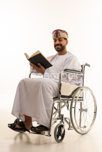 رجل عُماني على كرسي متحرك يقرأ كتاباً