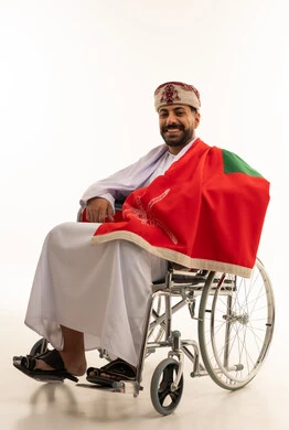 رجل عماني على كرسي متحرك مع العلم الوطني