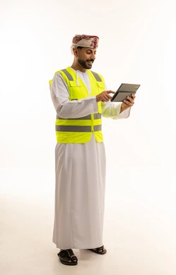 Omani Engineer in Safety Vest Using Digital Tablet