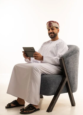Omani Man with Tablet in Traditional White Dishdasha