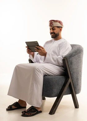 Omani Man in Traditional Dress Using Digital Tablet
