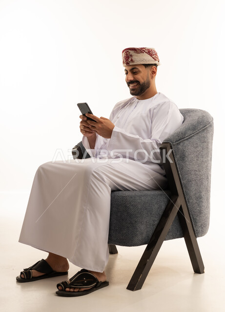 Omani Man with Smartphone in Traditional Attire
