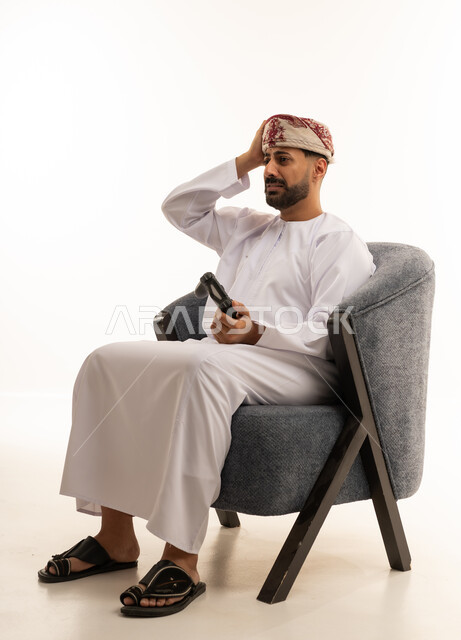 رجل عماني يلعب ألعاب الفيديو بخلفية بيضاء