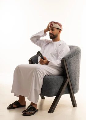 رجل عماني يلعب ألعاب الفيديو بخلفية بيضاء