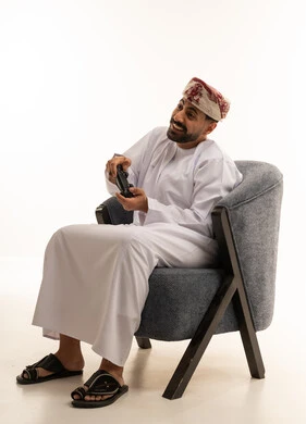 Omani Man Playing Video Games in Traditional Dress