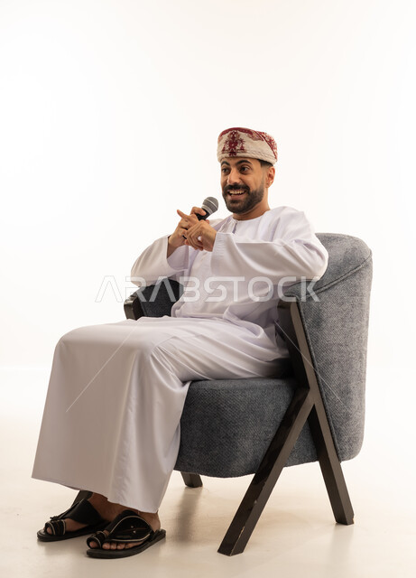 رجل عماني بالدشداشة التقليدية يتحدث في ميكروفون