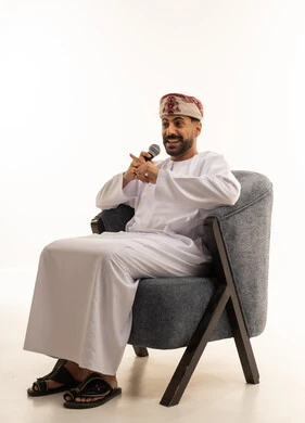 Omani Man in Traditional Dishdasha Speaking into Microphone