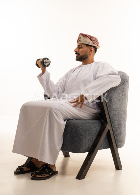 Omani Man Lifting Dumbbell in Traditional Dress