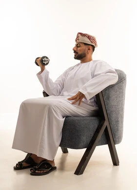 Omani Man Lifting Dumbbell in Traditional Dress