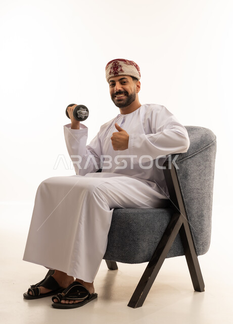رجل عماني يمارس الرياضة بالدمبل مع إيماءة الإبهام