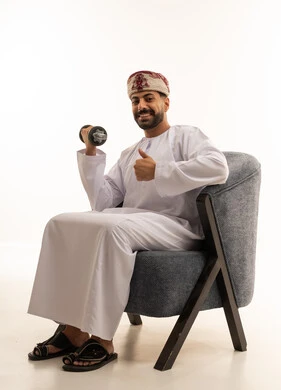 رجل عماني يمارس الرياضة بالدمبل مع إيماءة الإبهام